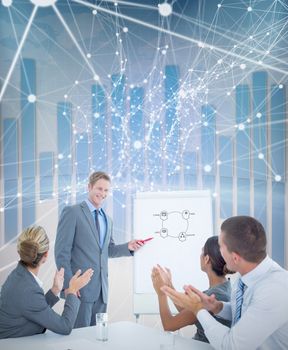 Manager presenting whiteboard to his colleagues against global business graphic in blue