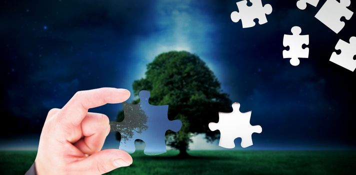 Hand showing against tree in field at night