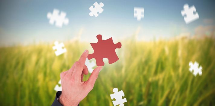 Businessman measuring something with these fingers against green meadow