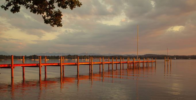 Reflections and jetty at Lake Starnberg  in the evening light