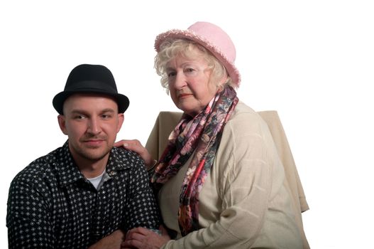 Grandmother in a pink hat and her grandson in a black  hat on a white background .