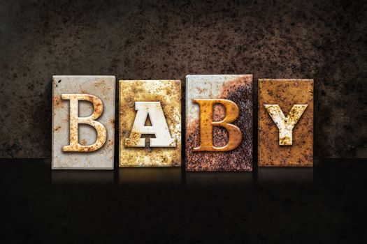 The word "BABY" written in rusty metal letterpress type on a dark textured grunge background.