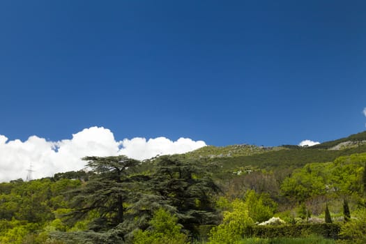 Clouds over mountains majestically float towards the sea