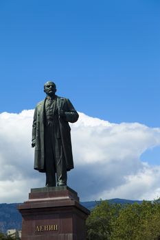 The monument to Lenin is among palm trees and against the bright blue sky