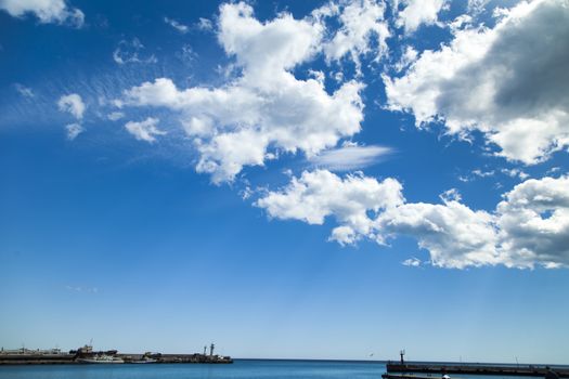 City bay with the ships in it under the blue sky and a bright sun