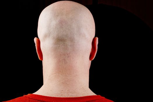 Bald head middle-aged man on a black background.