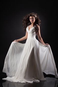 Young beautiful woman in a wedding dress on a black background