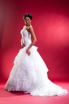 Young woman in a wedding dress on a studio background