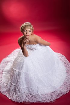 Young woman in a wedding dress on a studio background