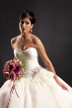 Young beautiful woman in a wedding dress on a black studio background