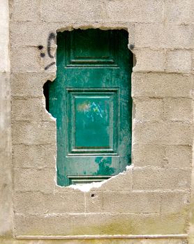 Green door behind cement blocks