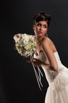 Young beautiful woman in a wedding dress on a black studio background