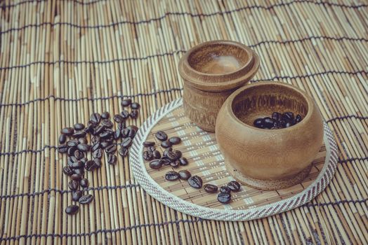 Coffee beans and coffee cup set on bamboo wooden background.Photo in retro color image style, Soft focus.