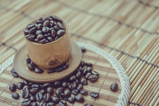 Coffee beans and coffee cup set on bamboo wooden background.Photo in retro color image style, Soft focus.