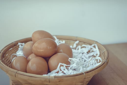 Eggs in a wicker basket on a wooden table