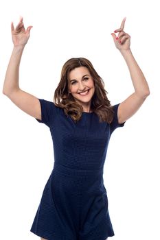 Happy woman pointing her finger upwards