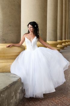 Young dark-haired beautiful woman in a wedding dress in diferent outdoor situations