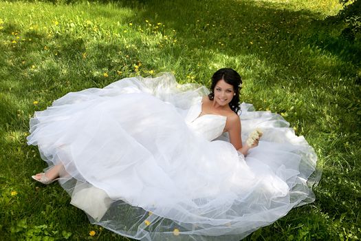 Young dark-haired beautiful woman in a wedding dress in diferent outdoor situations