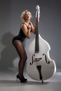 Young woman in a black underwear with a double bass