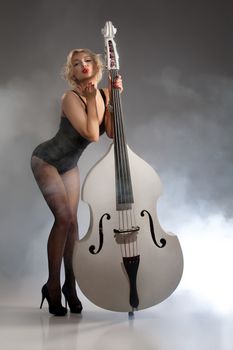 Young woman in a black underwear with a double bass