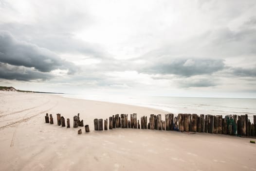 Poles in the sand at the beach in Tversted in Denmark