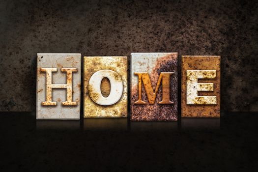 The word "HOME" written in rusty metal letterpress type on a dark textured grunge background.