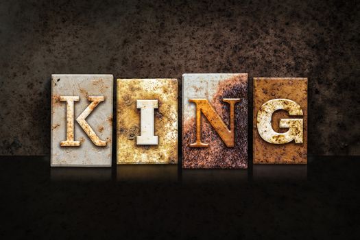 The word "KING" written in rusty metal letterpress type on a dark textured grunge background.