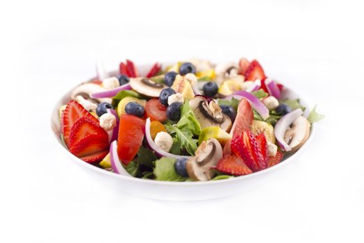 Detail of fresh colorful salad with healthy ingredients, berries, figs, greens and feta cheese