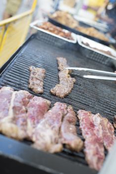 Pieces of meat cooking on a street food barbecue