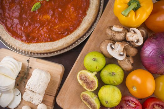 Rustic home made pizza on wooden table with fresh ingredients and cheese