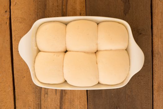 baking dish with yeast dough in the form of an bun