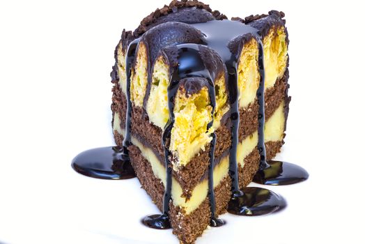 a piece of isolated vanilla and chocolate cake with chocolate sauce