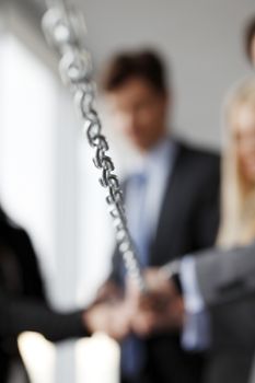Businessmen pulling chain, teamwork togetherness concept