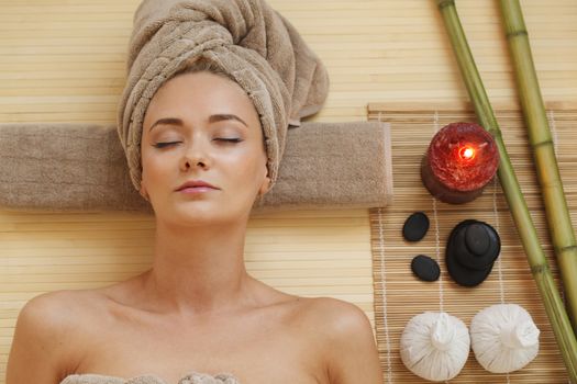 Beautiful young woman relaxing in spa salon