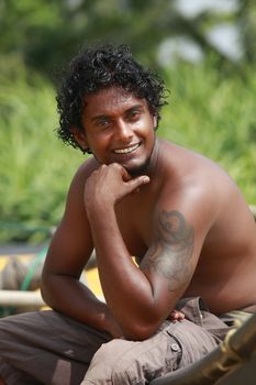 The young man sitting by a boat. Sri Lanka