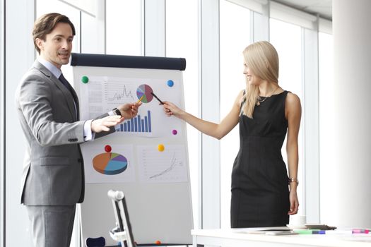 Workers at business meeting looking at presentation of financial reports in modern office