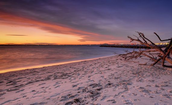 Sunset at Silver Beach, Botany Bay, Sydney with Port Botany and city of Sydney in the far distance.