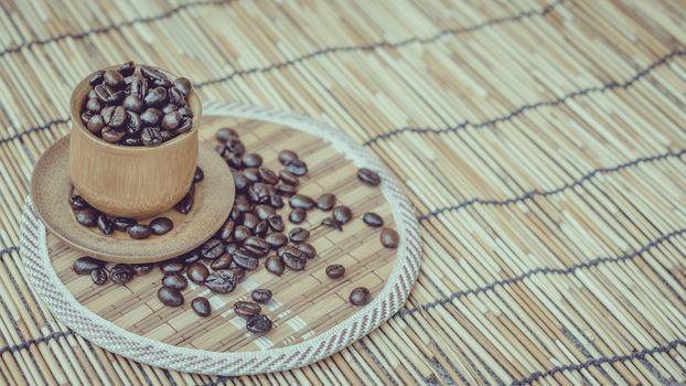 Coffee beans and coffee cup set on bamboo wooden background.Photo in retro color image style, Soft focus.