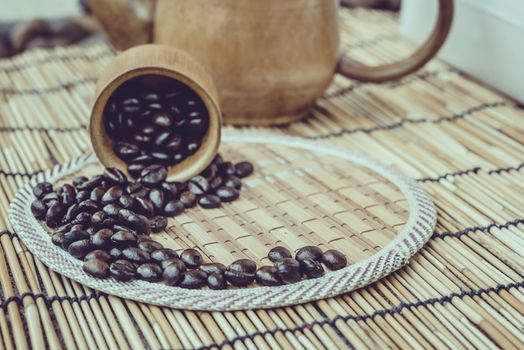 Coffee beans and coffee cup set on bamboo wooden background.Photo in retro color image style, Soft focus.