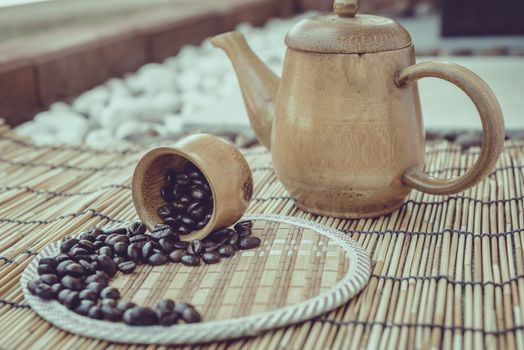 Coffee beans and coffee cup set on bamboo wooden background.Photo in retro color image style, Soft focus.