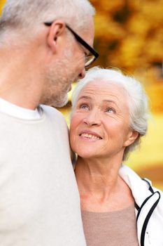 family, age, tourism, travel and people concept - senior couple hugging in city park