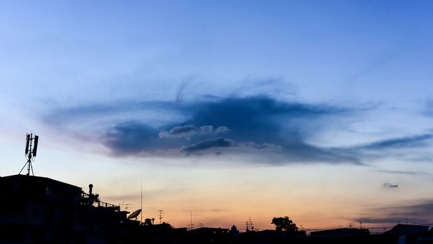 Nice cloud shape in sunset sky with building silhouette