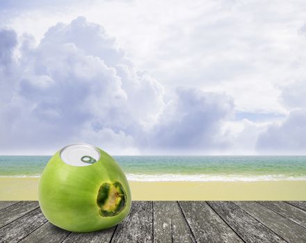 Fresh coconut with can open tool on top and sea background