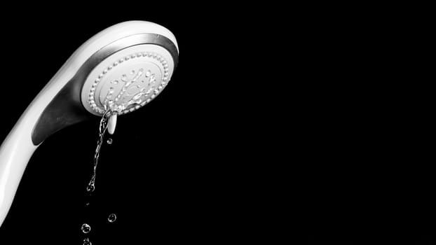 Modern shower head with running water isolated on black background