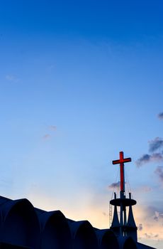 Cross at top of chruch with sunset sky background