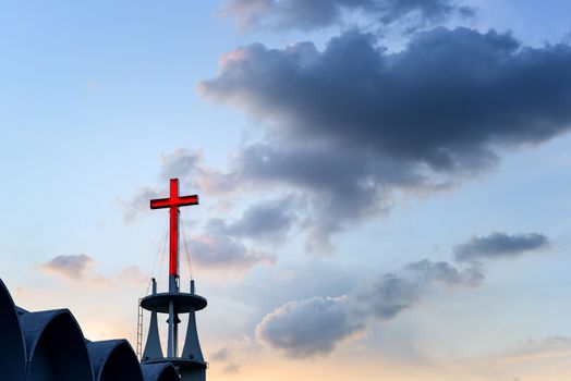 Cross at top of chruch with sunset sky background