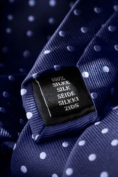 Label of a tie made of silk. Short depth of field, the sharpness is in the word Silk.