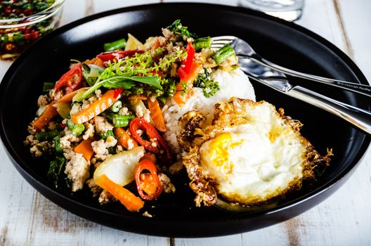 Thai spicy food basil pork fried with rice and fried egg and chili fish sauce,Pad Kra Pao moo