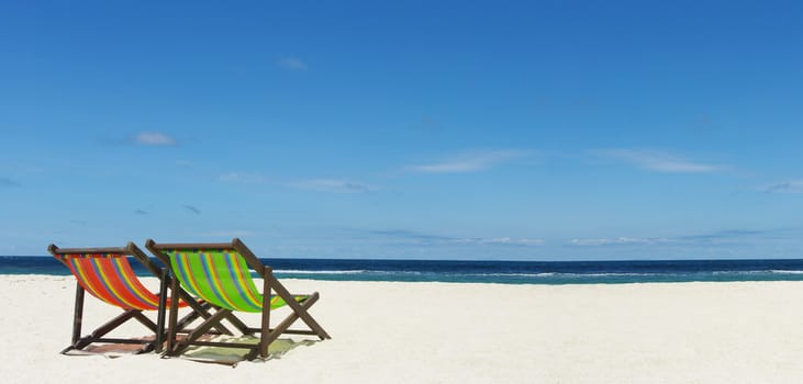 Beach chair on sand beside nice sea, Summer time concept