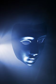 Blank mask in blue hazy light. Short depth of field.